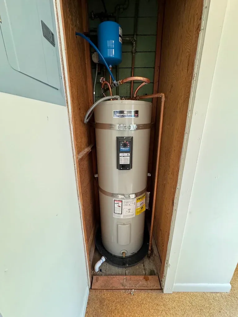 Bradford White electric water heater in a closet with expansion tank and drain pan