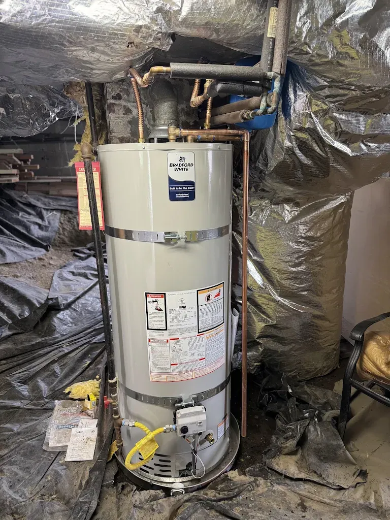 Bradford White gas water heater installed in a crawlspace with insulated copper lines and yellow gas flex
