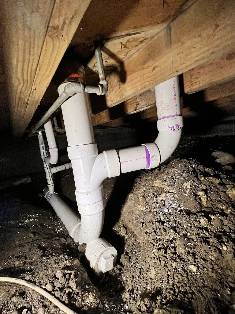 New PVC drain, wye and cleanout under floor joists in a crawlspace