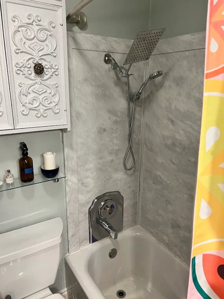 Marble-look tub surround with square rain shower head and handheld sprayer